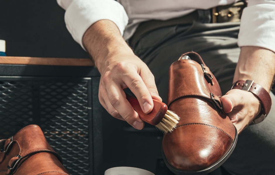 homme qui nettoie une chaussure en cuir